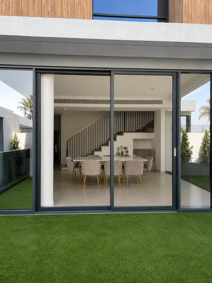 Black-framed sliding doors seen from the villa garden, Arabian Ranches III