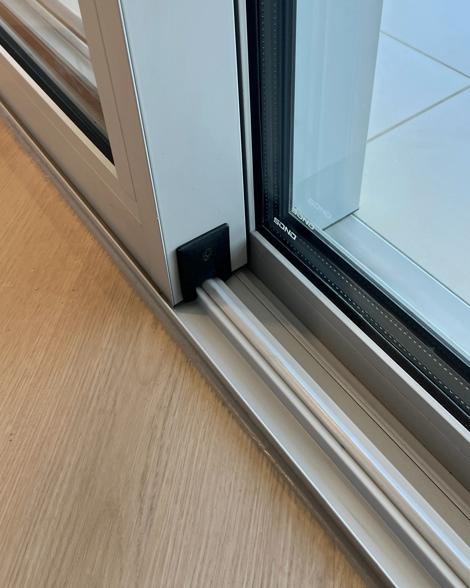 Lift-and-slide door track and threshold detail on timber flooring, Burj Daman
