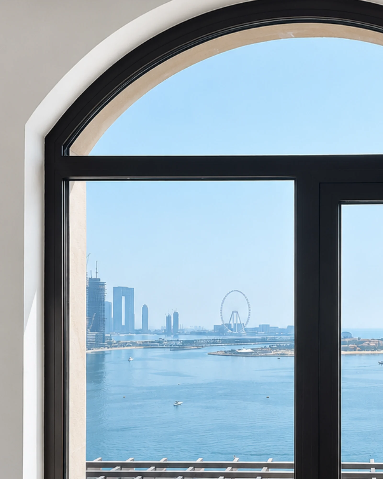Arched black-framed window with sea view toward Ain Dubai, Fairmont Palm apartment