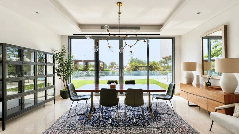 Dining room with full-height sliding doors onto the garden, Yas Acres villa